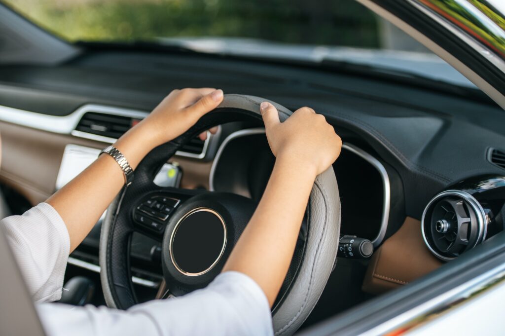 man holding steering wheel in car