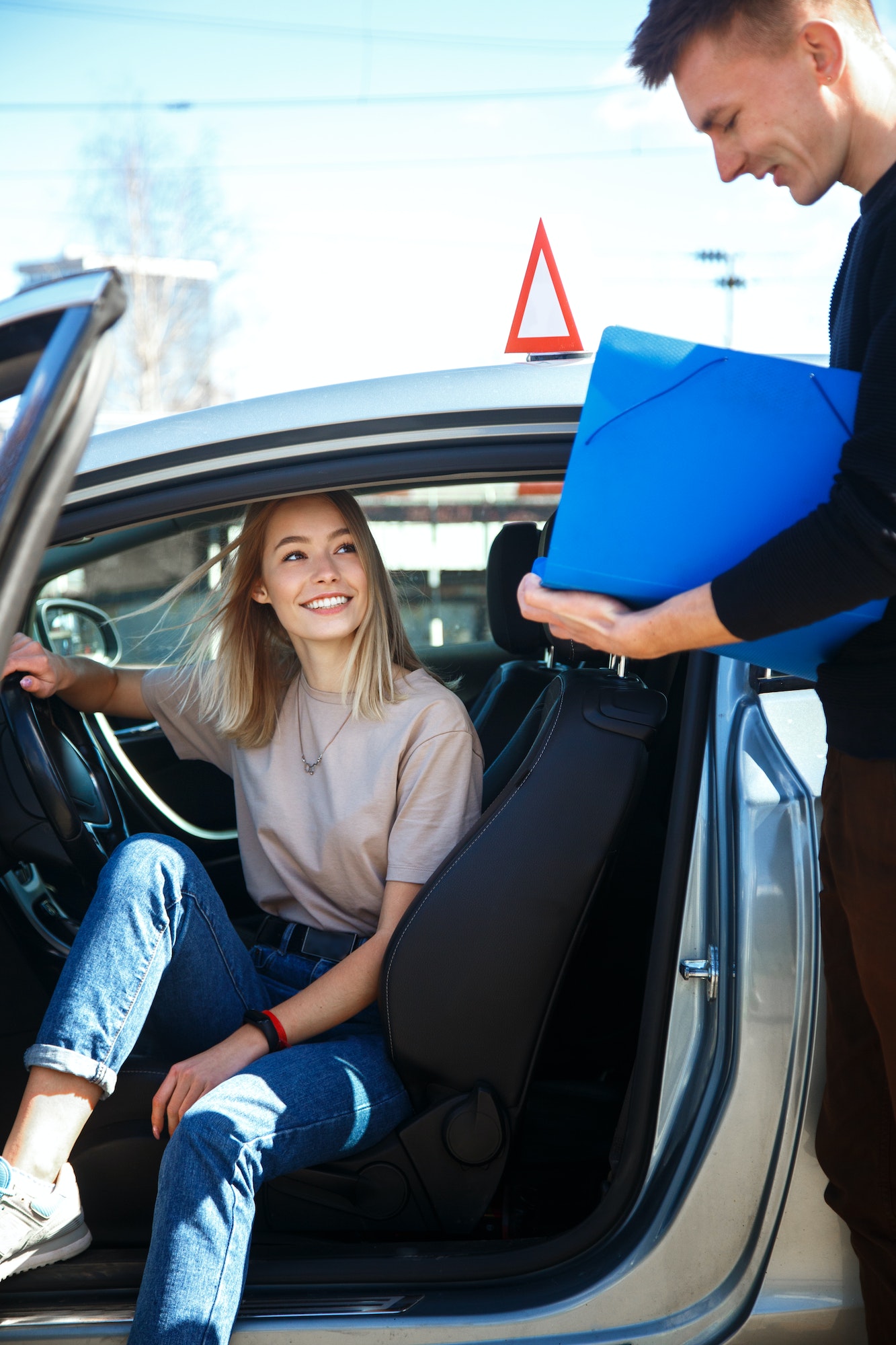 Driving instructor and woman student in examination car.